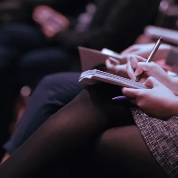 A representative taking notes during a Technologise conference event.
